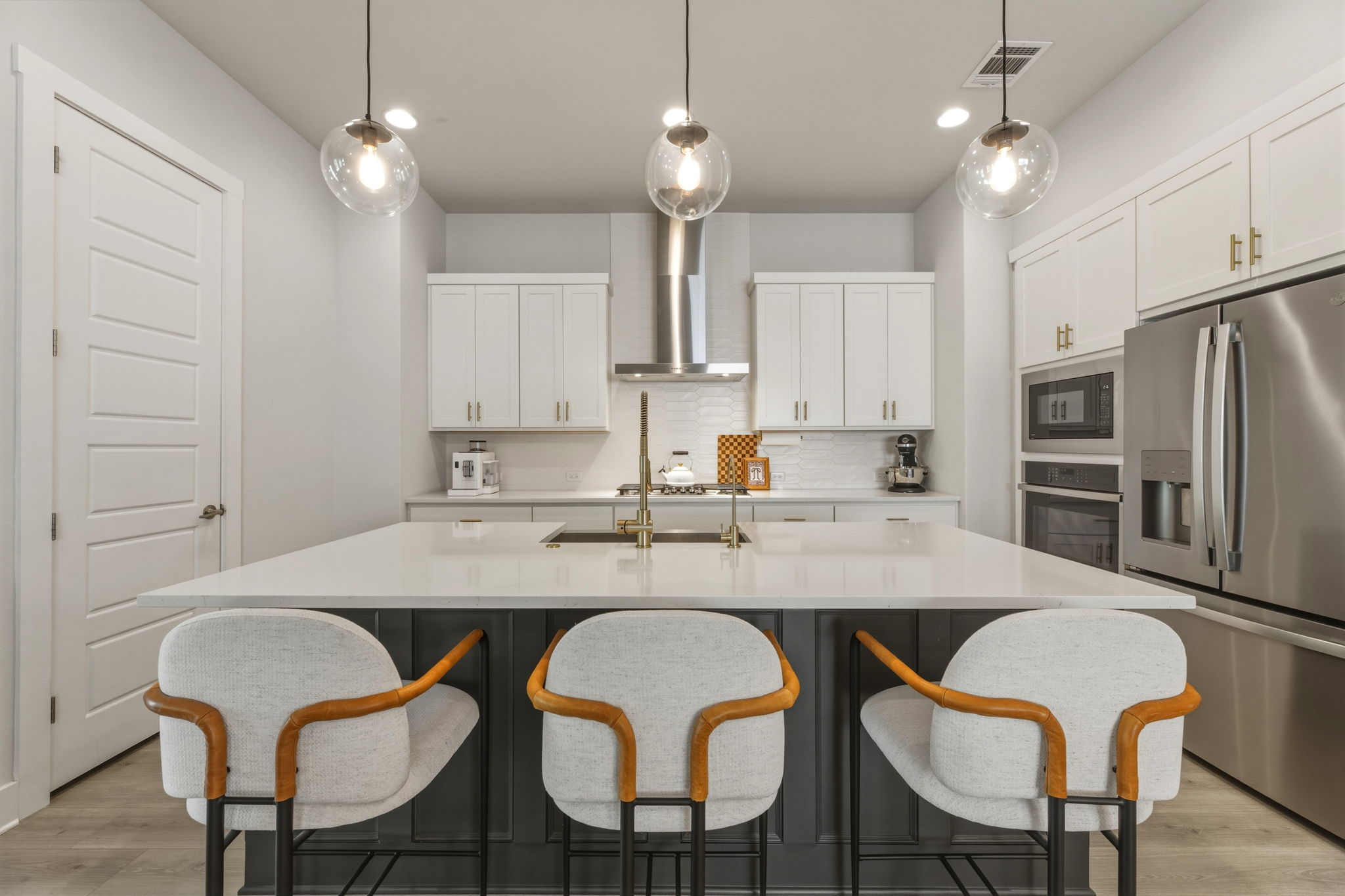 4505 Post Loop Round Rock, TX 78681 - Photo 17 of 40 Kitchen featuring stainless steel appliances, an island with sink, a breakfast bar, two tone cabinetry, and pendant lighting