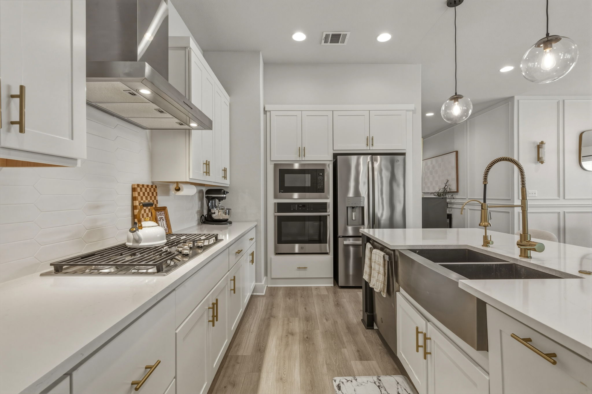 4505 Post Loop Round Rock, TX 78681 - Photo 18 of 40 Kitchen featuring white cabinetry, stainless steel appliances, light wood-style flooring, and light stone countertops
