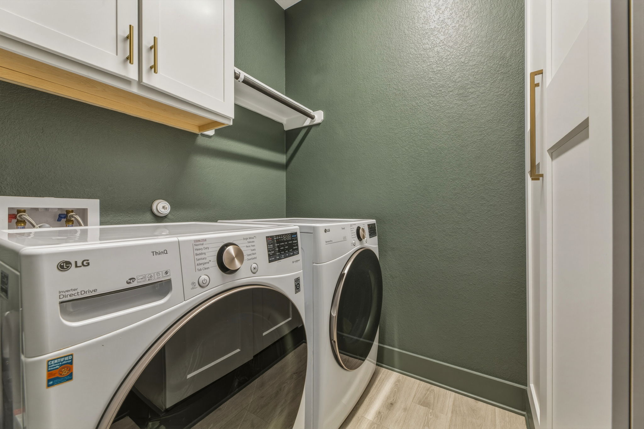 4505 Post Loop Round Rock, TX 78681 - Photo 19 of 40 Laundry area featuring a textured wall, cabinet space, light wood-style floors, and washer and clothes dryer