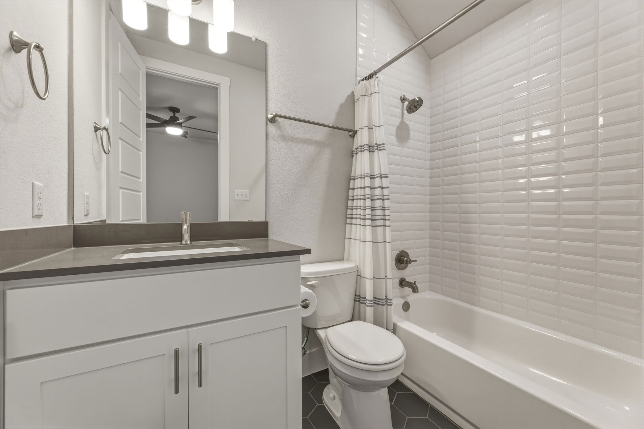 4505 Post Loop Round Rock, TX 78681 - Photo 29 of 40 Full bath with vanity, shower / bathtub combination with curtain, dark tile patterned flooring, ceiling fan, and a textured wall