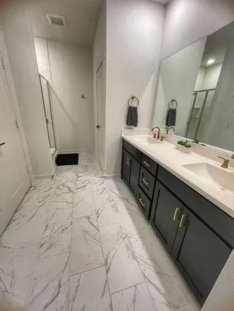 a spacious bathroom with a double vanity sink and mirror