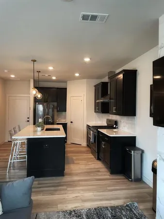 a kitchen with stainless steel appliances kitchen island granite countertop a sink and a stove