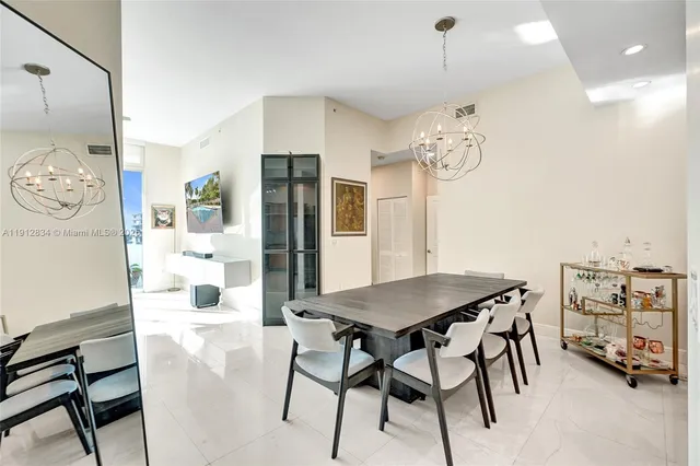 a view of a dining room with furniture and a chandelier