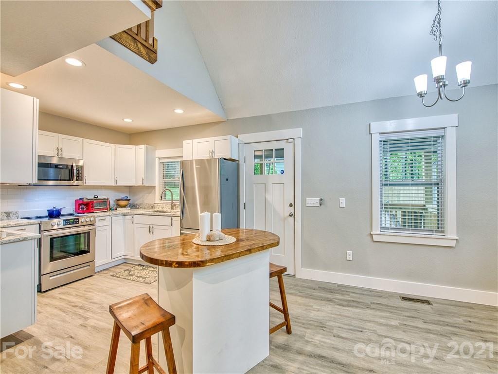 90 Ash Drive Maggie Valley, NC 28751 - Photo 8 of 24 a kitchen with stainless steel appliances kitchen island granite countertop a stove a sink dishwasher and a refrigerator with wooden floor