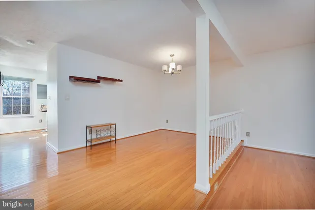 a view of a livingroom with wooden floor and a staircase