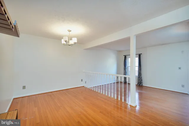 a view of a room with wooden floor and chandelier