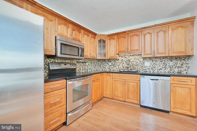 a kitchen with stainless steel appliances granite countertop a stove microwave and cabinets