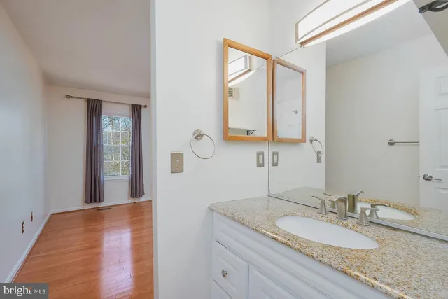 a bathroom with a granite countertop sink and a mirror