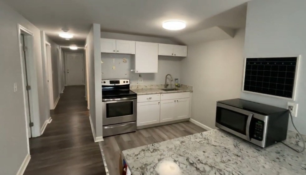 155 Onset Avenue, Unit E Wareham, MA 02558 - Photo 2 of 5 a kitchen with a sink stove and cabinets
