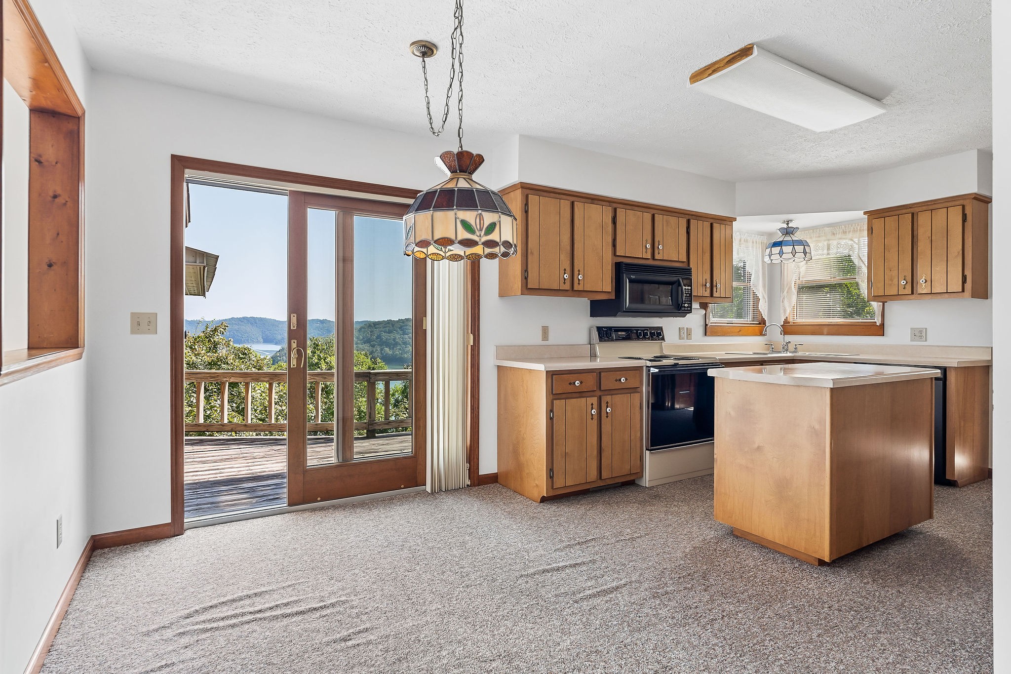 309 Cedar Hill Road Celina, TN 38551 - Photo 25 of 60 a kitchen with stainless steel appliances granite countertop a stove a sink dishwasher a refrigerator and a dining table with wooden floor