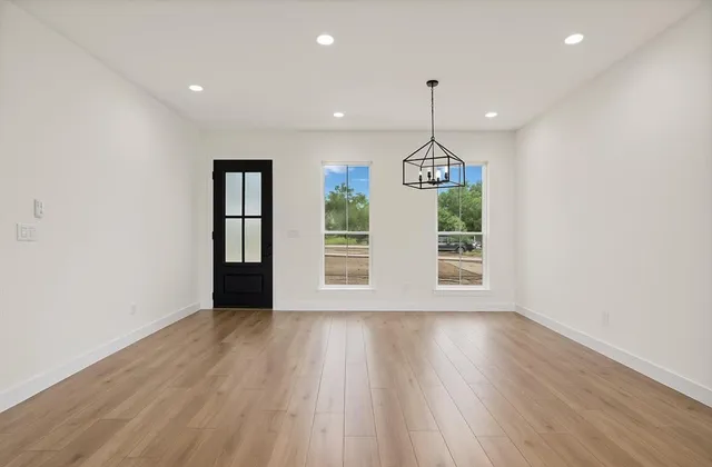 a view of a room with wooden floor ceiling fan and window