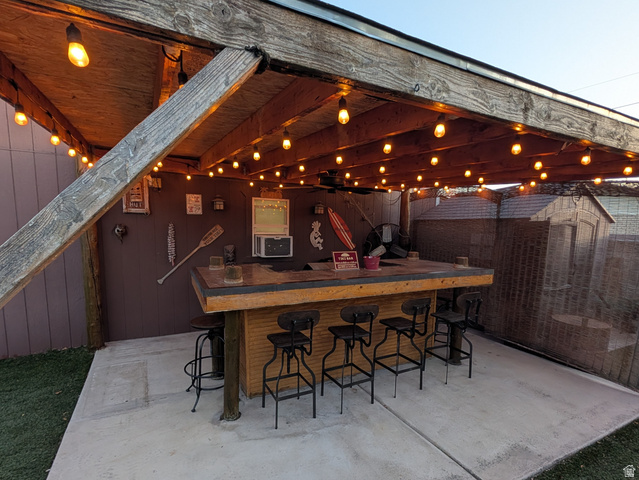 8252 Wood Street Midvale, UT 84047 - Photo 27 of 40 Outdoor patio bar featuring a wood-finish countertop, built-in cabinetry, and overhead string lighting