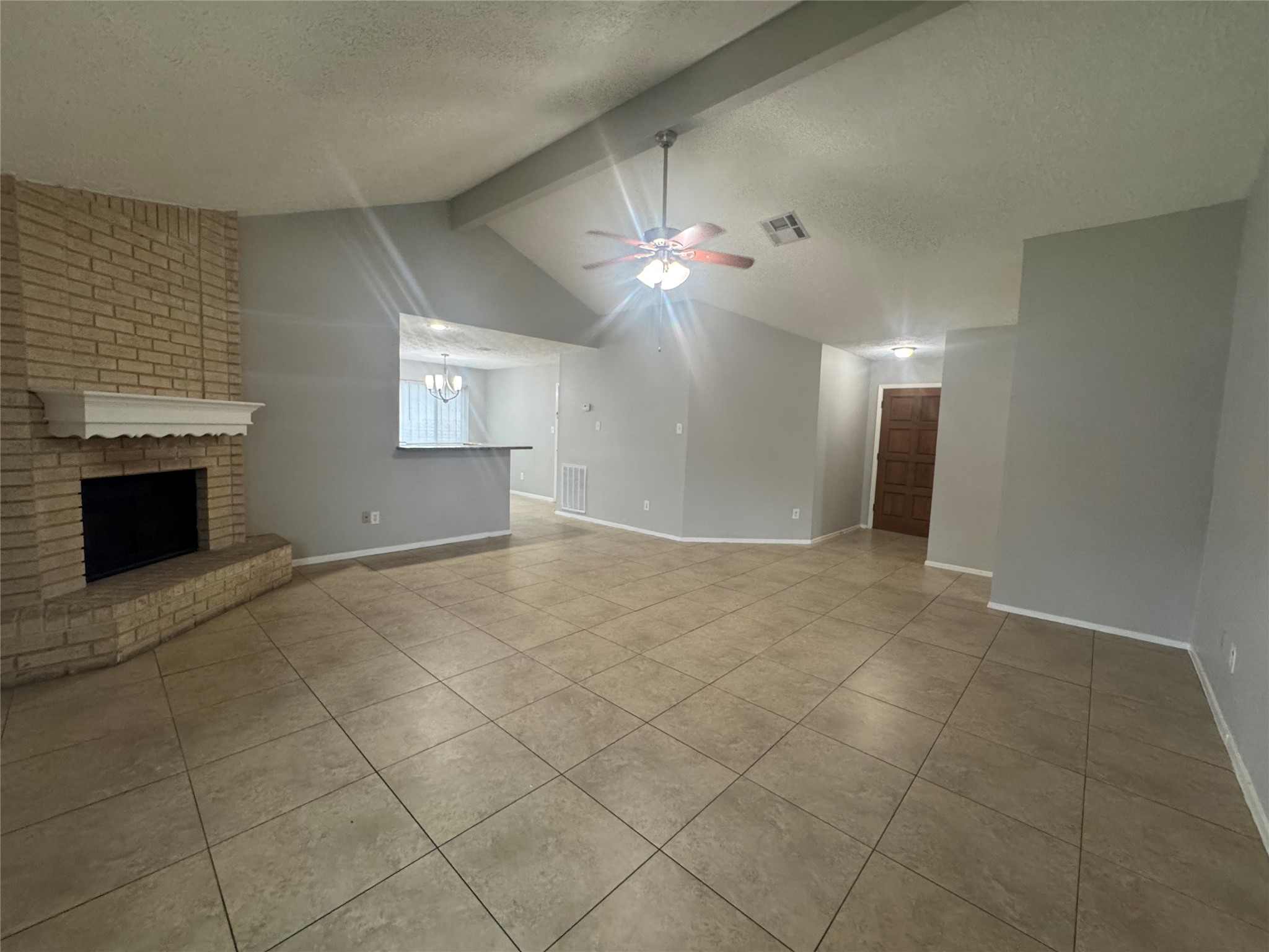 13327 Reads Court Houston, TX 77015 - Photo 3 of 17 an empty room with a fireplace and chandelier fan