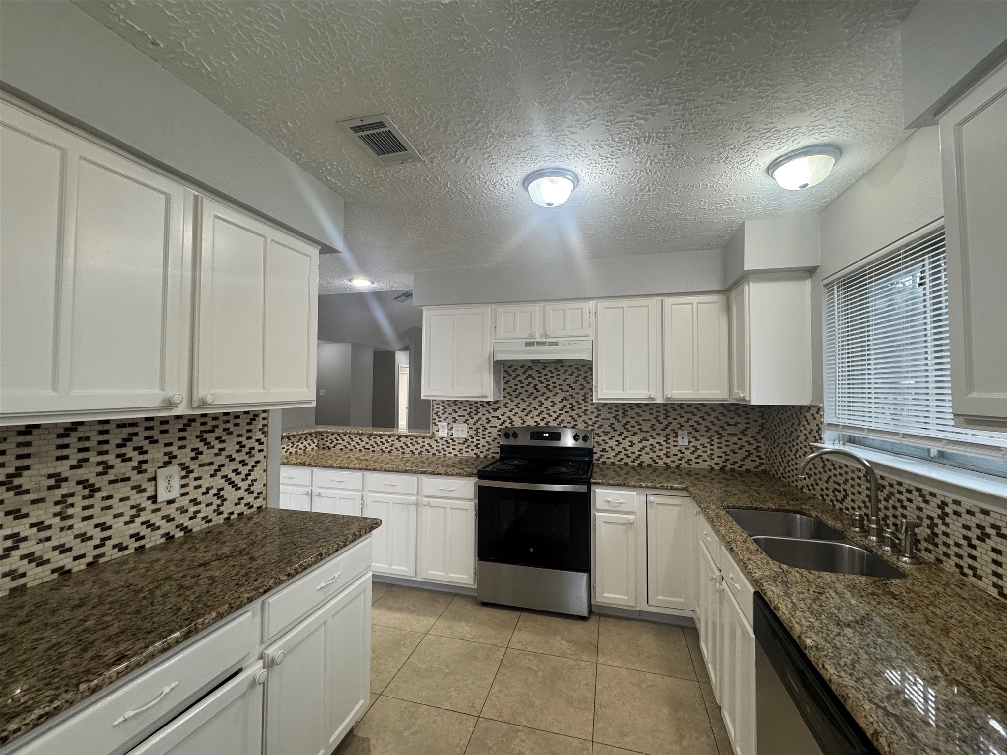 13327 Reads Court Houston, TX 77015 - Photo 7 of 17 a kitchen with granite countertop a sink stove and cabinets