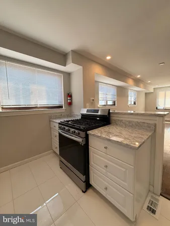 a kitchen with granite countertop a stove and a sink