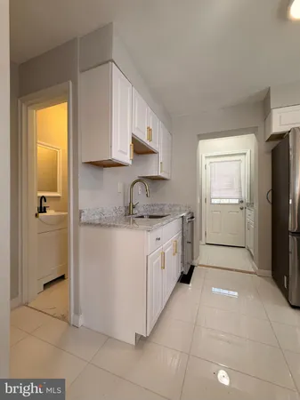 a kitchen with a refrigerator sink and cabinets