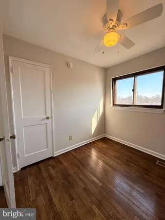 an empty room with wooden floor and window
