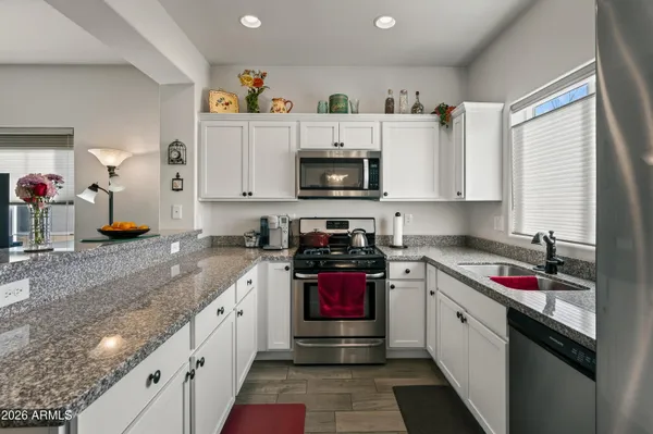 a kitchen with stainless steel appliances granite countertop a sink and a microwave