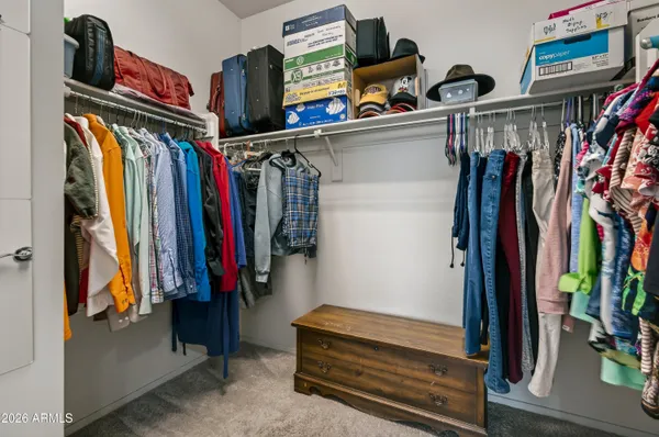 a view of walk in closet with clothes and shoes