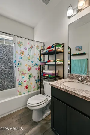 a bathroom with a granite countertop toilet sink and mirror