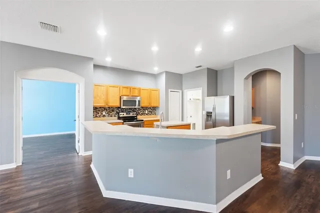 a view of kitchen with stainless steel appliances granite countertop a large counter top and stove