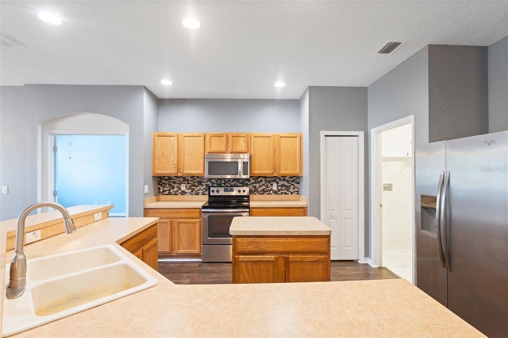 14027 Bensbrook Drive Spring Hill, FL 34609 - Photo 17 of 61 a kitchen with stainless steel appliances granite countertop a refrigerator and a stove top oven