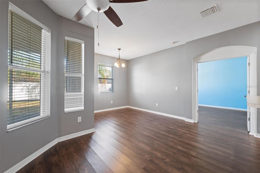 14027 Bensbrook Drive Spring Hill, FL 34609 - Photo 21 of 61 an empty room with wooden floor and windows