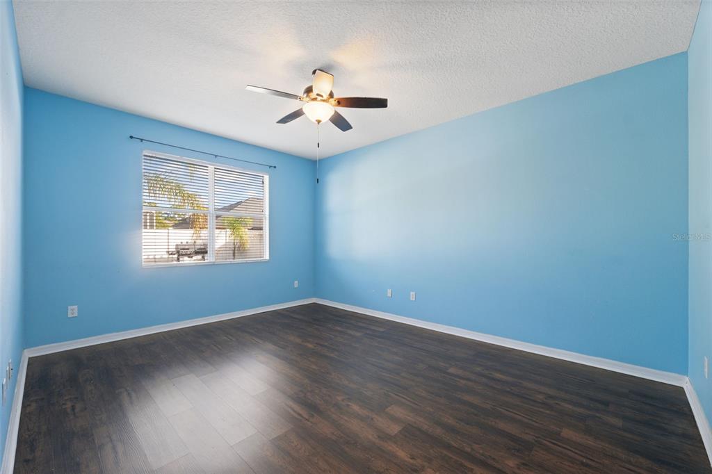 14027 Bensbrook Drive Spring Hill, FL 34609 - Photo 22 of 61 a view of an empty room with wooden floor and a window