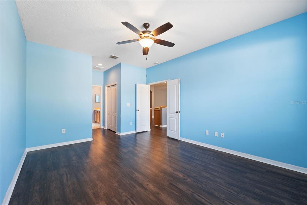 14027 Bensbrook Drive Spring Hill, FL 34609 - Photo 23 of 61 a view of an empty room with wooden floor and a ceiling fan