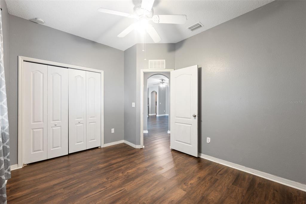 14027 Bensbrook Drive Spring Hill, FL 34609 - Photo 36 of 61 an empty room with wooden floor and ceiling fan