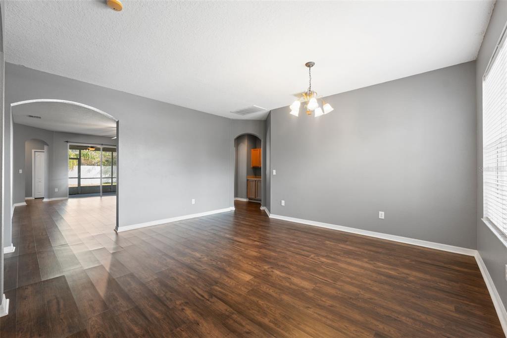 14027 Bensbrook Drive Spring Hill, FL 34609 - Photo 4 of 61 a view of an empty room with wooden floor and a window