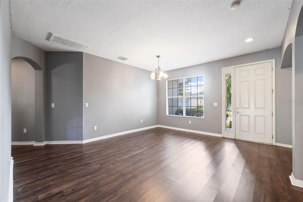 14027 Bensbrook Drive Spring Hill, FL 34609 - Photo 5 of 61 a view of an empty room with wooden floor and a window
