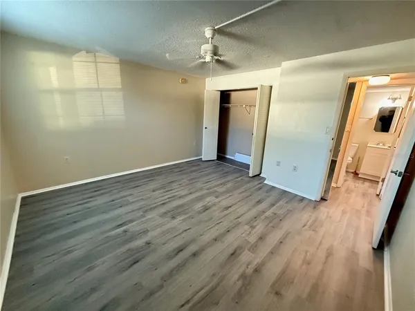 an empty room with wooden floor and mirror