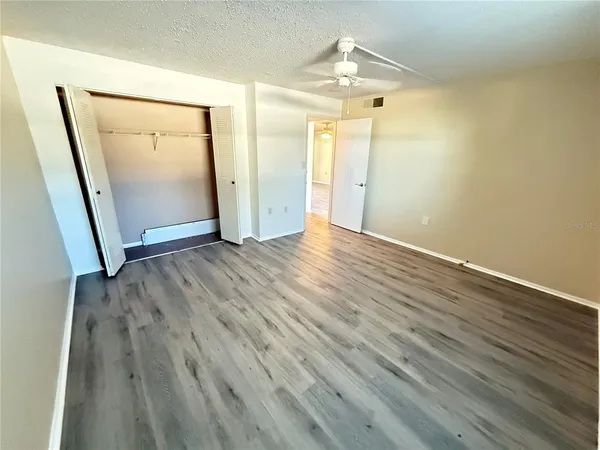 an empty room with wooden floor and mirror