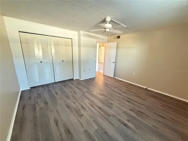 an empty room with wooden floor and mirror