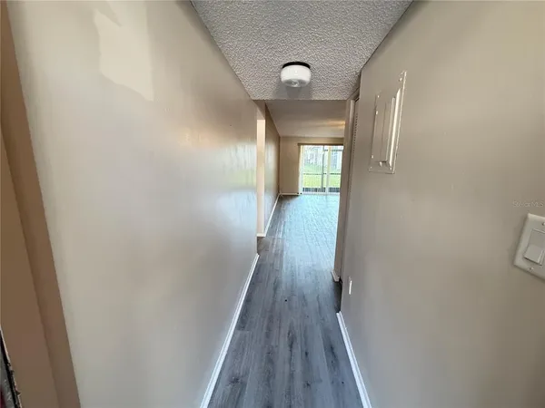 a view of a hallway with wooden floor