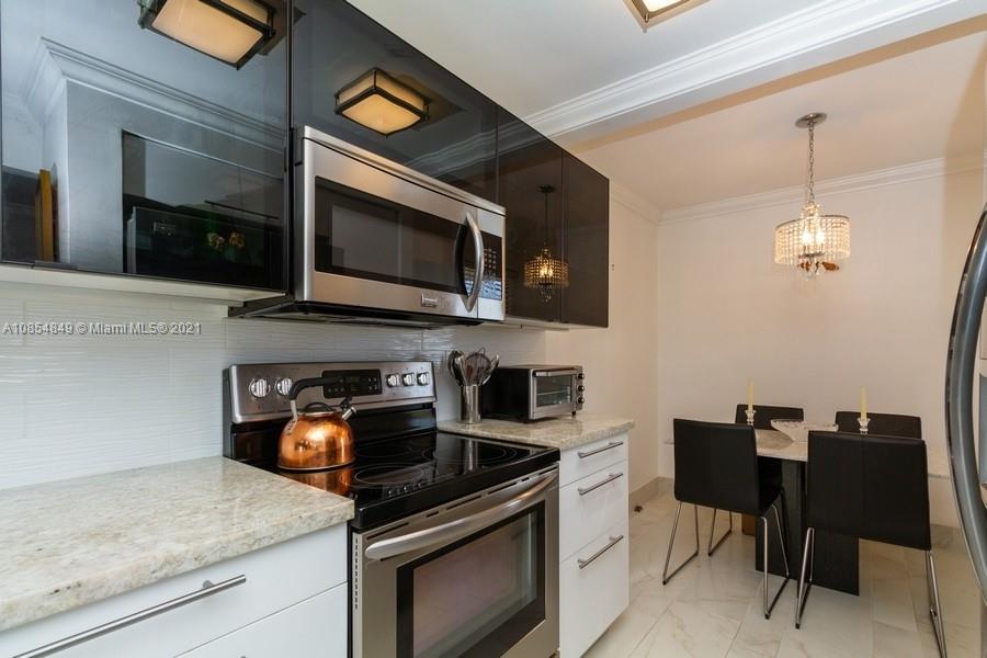 14 Royal Palm Way, Unit 5010 Boca Raton, FL 33432 - Photo 4 of 15 a kitchen with stainless steel appliances granite countertop a stove and a microwave
