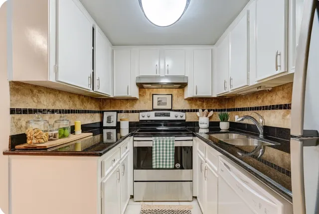 a kitchen with stainless steel appliances granite countertop a sink stove and cabinets