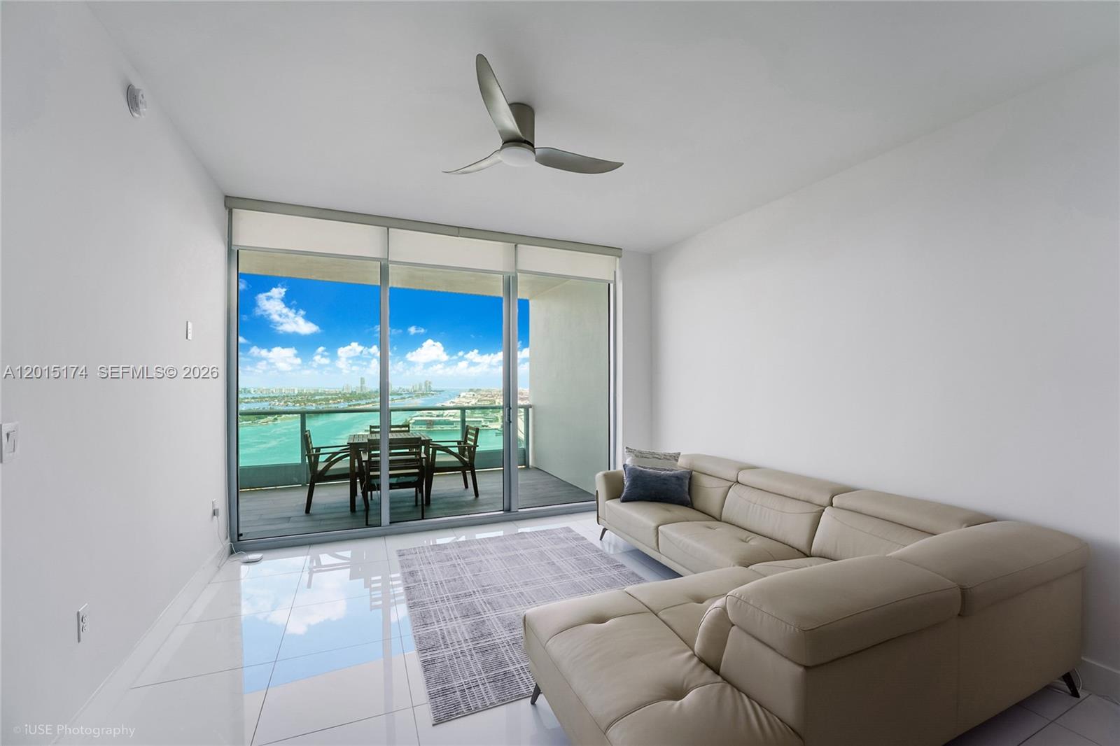 900 Biscayne Boulevard, Unit 3407 Miami, FL 33132 - Photo 5 of 15 a living room with furniture a chandelier and a floor to ceiling window