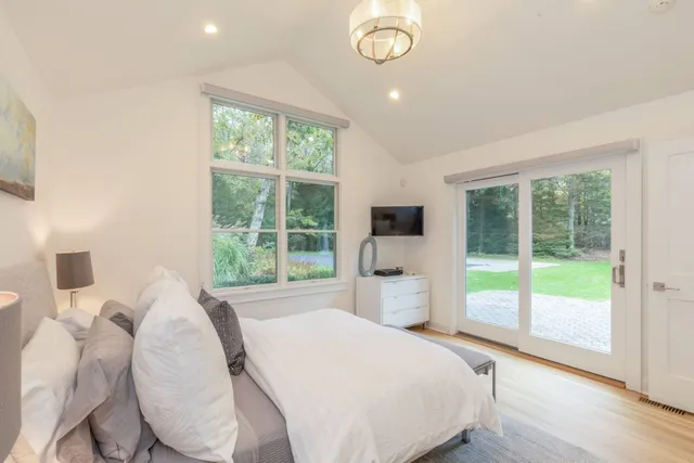 a bedroom with a bed and a large window