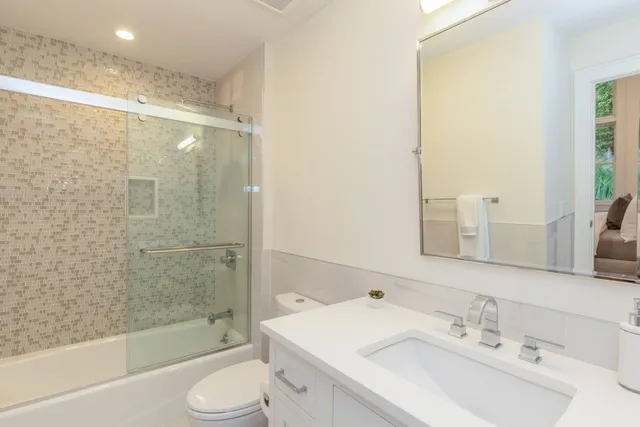 a bathroom with a sink mirror toilet and bathtub
