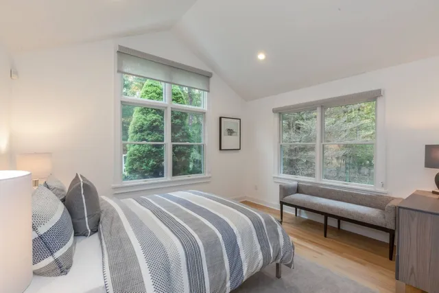 a bedroom with a bed and a large window