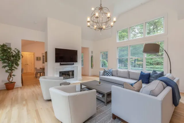 a living room with furniture a flat screen tv and a large window