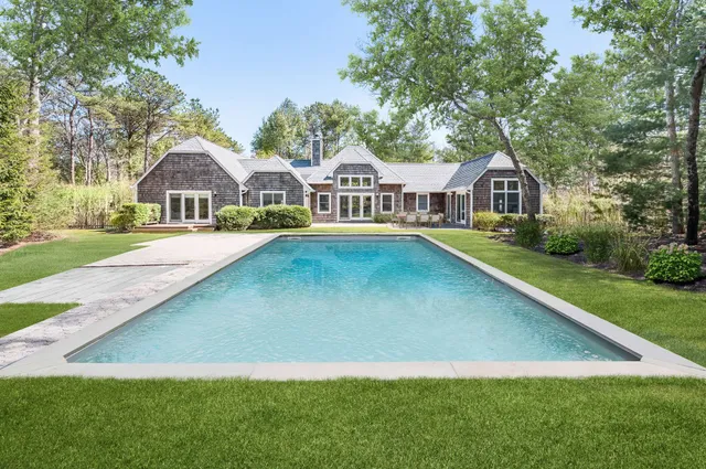 a front view of a house with a yard and trees