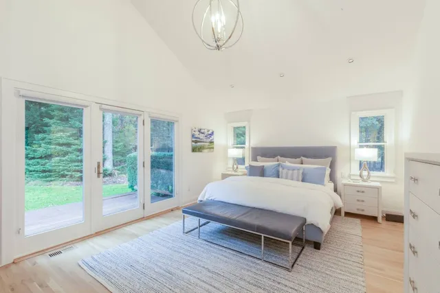 a spacious bedroom with a bed and wooden floor