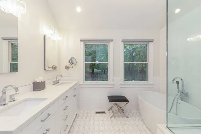 a bathroom with a tub sink a toilet and a window