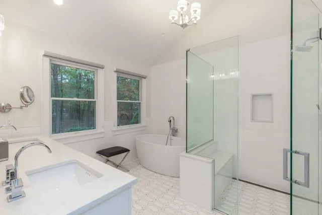 a bathroom with a tub sink and mirror