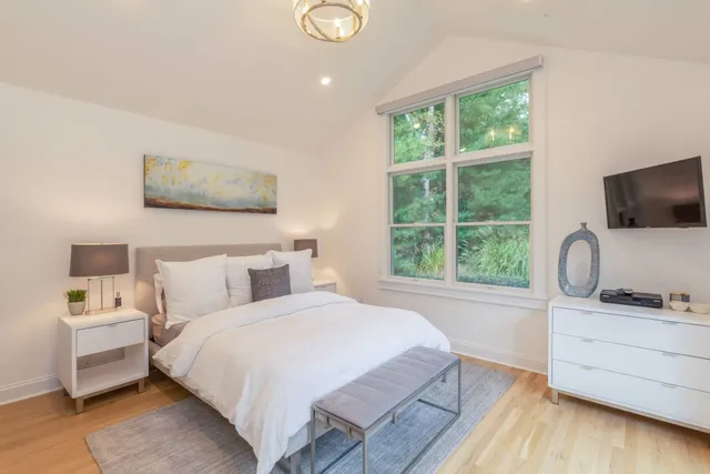 a bedroom with a bed and a flat screen tv