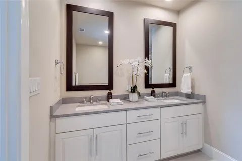 a bathroom with a granite countertop sink double and mirror