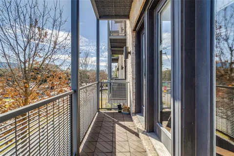 a view of a balcony with wooden floor and floor to ceiling window